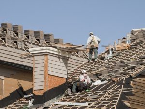 Roofers with tile stack on multi angle roof